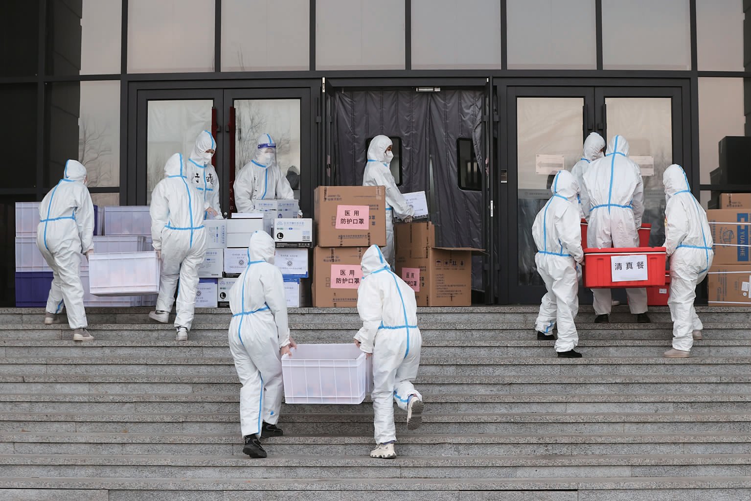 辅导员带领志愿者为学生搬运早餐和防疫物品。他们把每一份饭和物品分发到寝室门口。