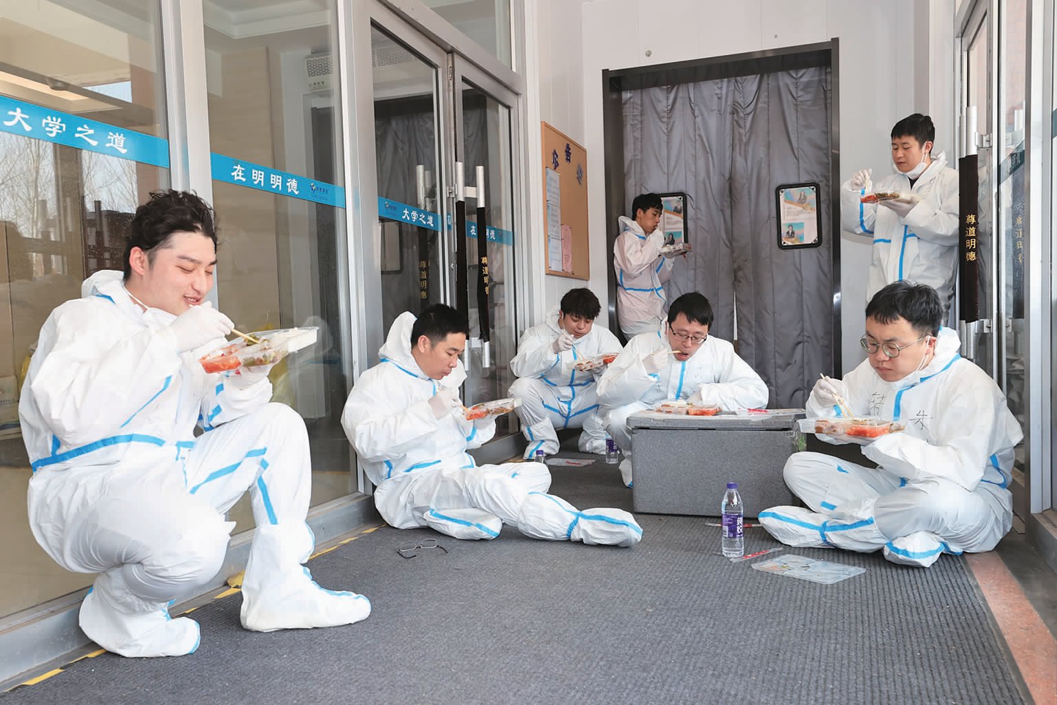 寝室里的同学们都吃上饭了,志愿者们才席地而坐,抓紧吃饭。